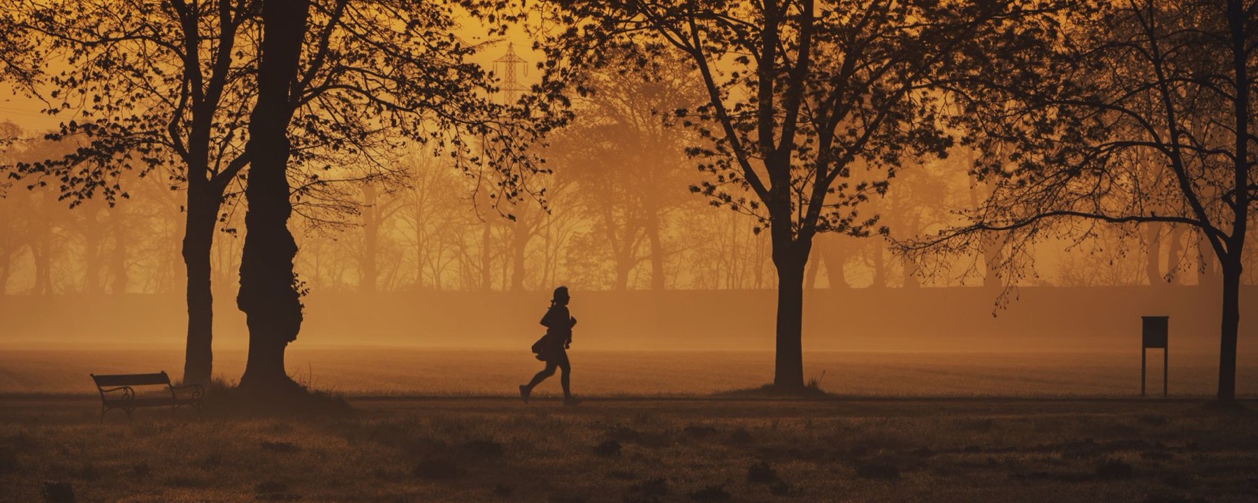 A runner at sunrise, silhouetted against the light
